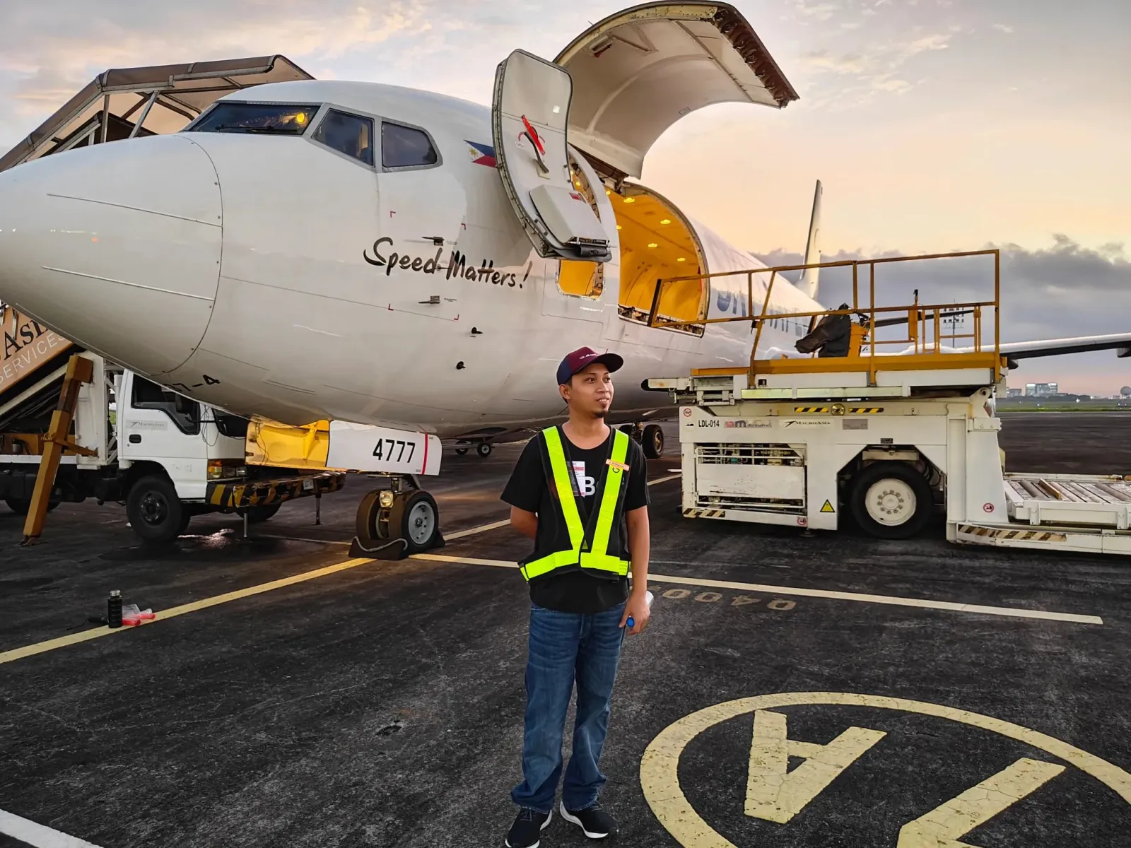 A freighter being loaded on stand at sunrise, cargo door open