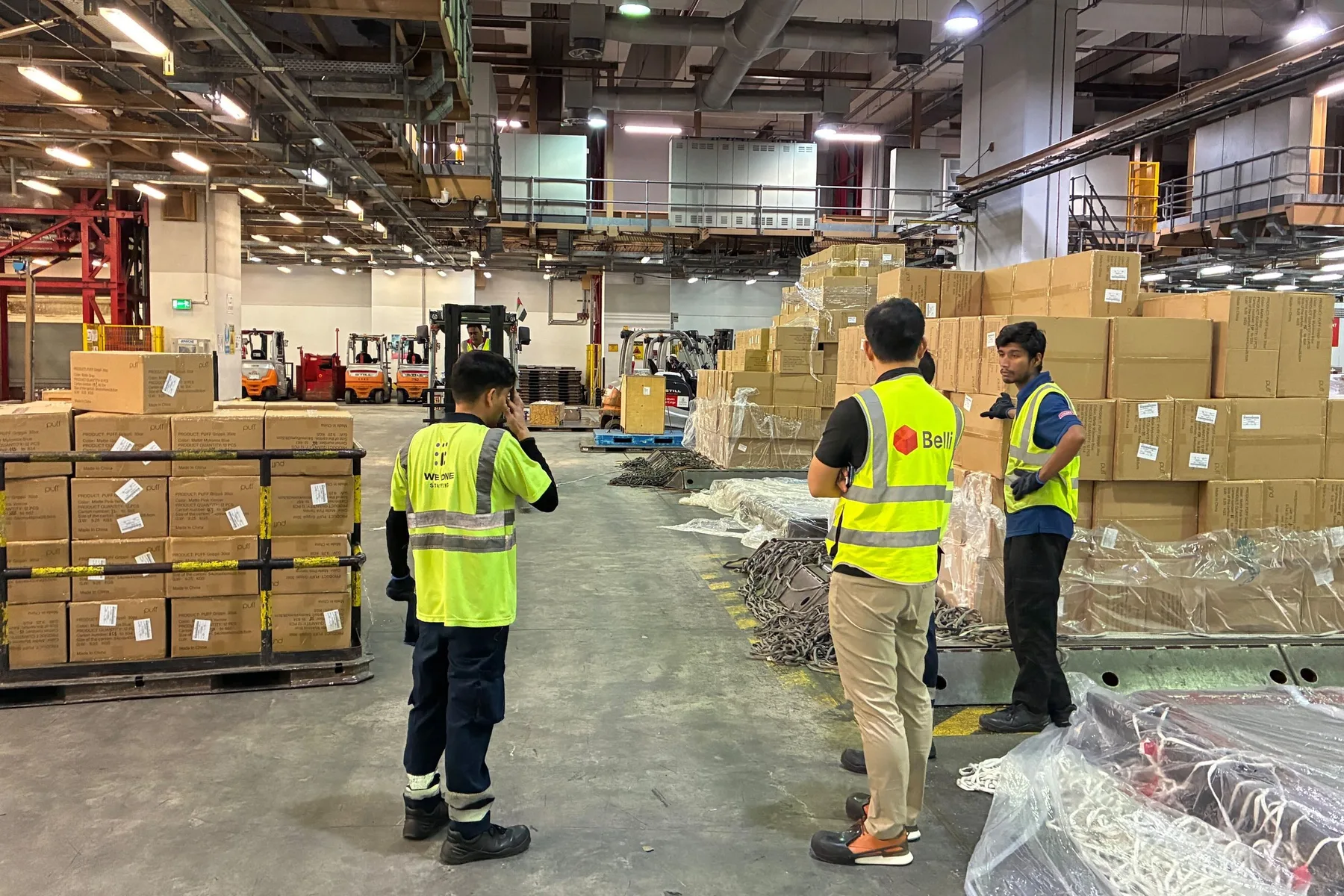 Belli and Emirates SkyCargo staff discussing pallets in the warehouse